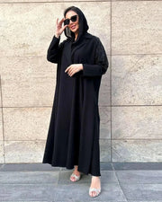 black crepe blazer abaya with tailored silhouette and hand embroidery on upper arms worn with sunglasses and sandals