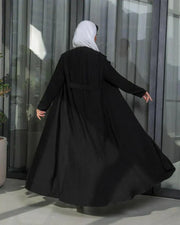 Black blazer-style abaya in crepe fabric with tailored front and soft pleats at the back, featuring sharp lapels and a clean silhouette.