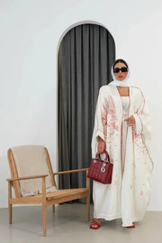 White linen bisht abaya with red hand embroidery and red trim, styled with a red handbag and sandals - Strawberry Cheesecake