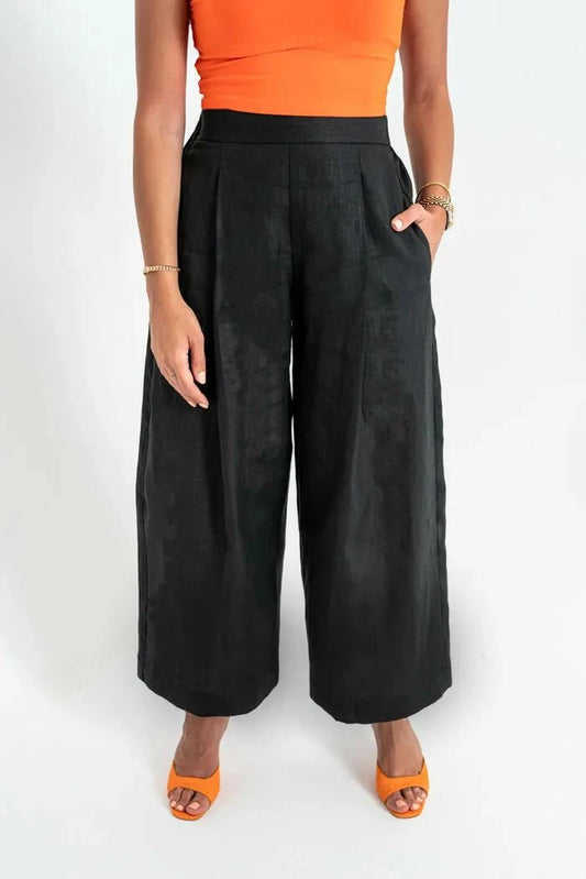 Woman wearing black linen wide-leg pants with side pockets and orange heels