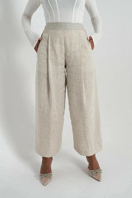 Beige linen pants with wide legs worn with white top and heels