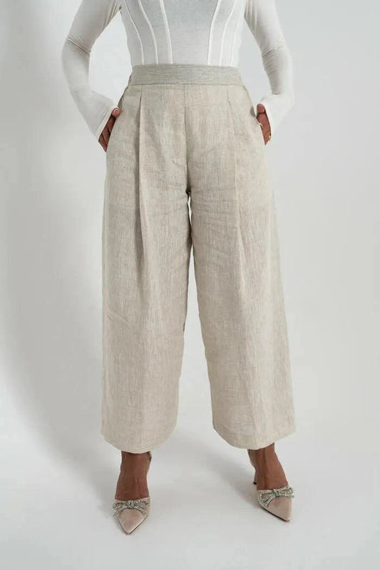 Beige linen pants with wide legs worn with white top and heels