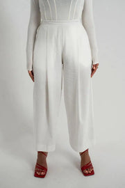 White linen pants with wide-leg cut and high waist featuring side pockets