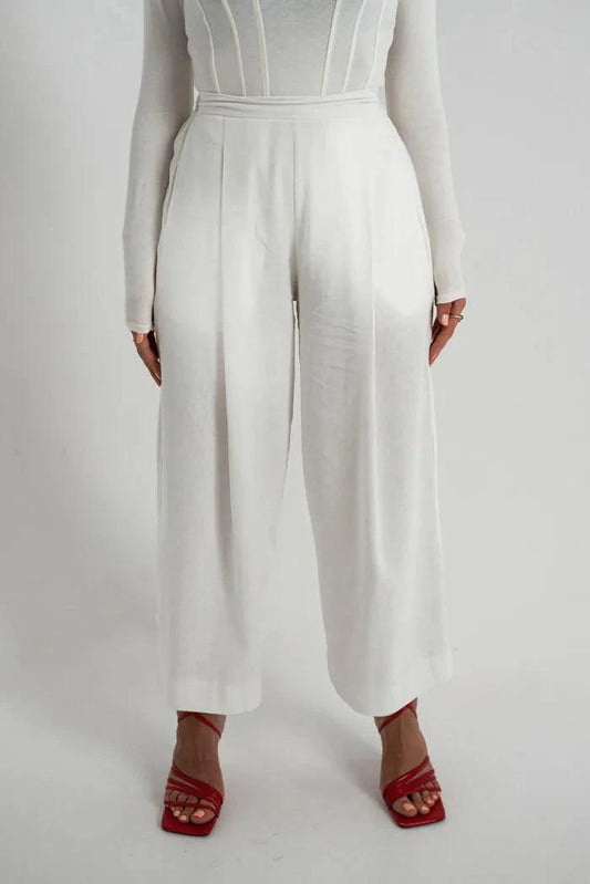 White linen pants with wide-leg cut and high waist featuring side pockets