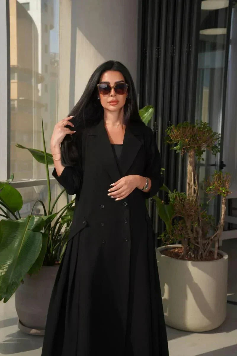 woman wearing a stylish black crepe blazer with double-breasted front and three buttons on each side in a modern indoor setting