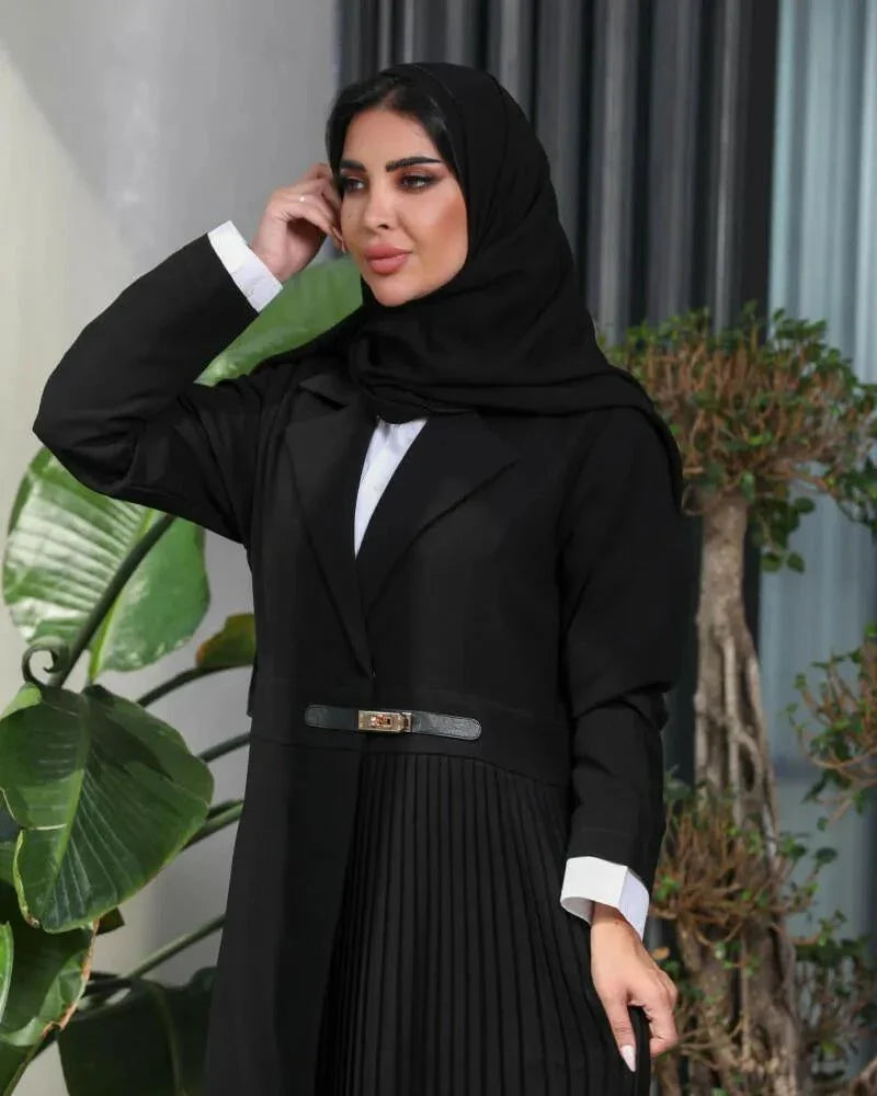Woman wearing black blazer-style abaya with pleated panel and slim belt