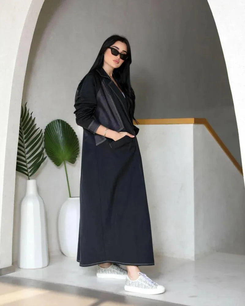 Denara casual-cool dark denim trench-style abaya with sharp lapels, flap pockets, contrast topstitching, and sleek streetwear silhouette.