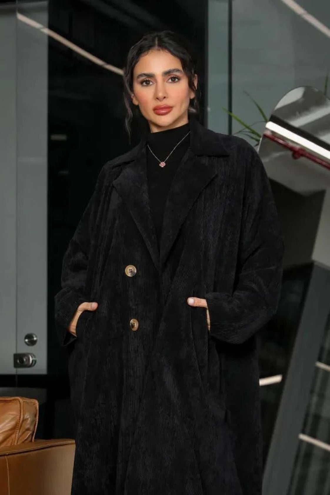Black velvet corduroy abaya with blazer-style cut worn by a woman indoors