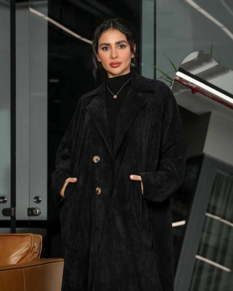 Black velvet corduroy abaya with blazer-style cut worn by a woman indoors