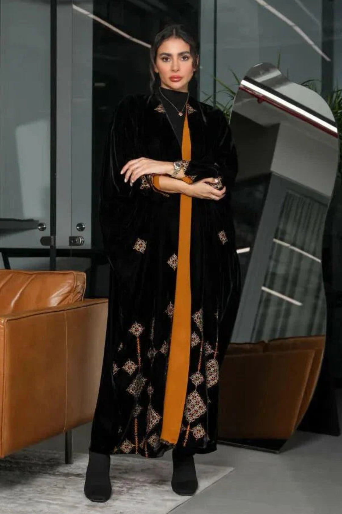 luxurious black velvet abaya with gold and beige geometric embroidery and bold orange chiffon lining in a relaxed silhouette
