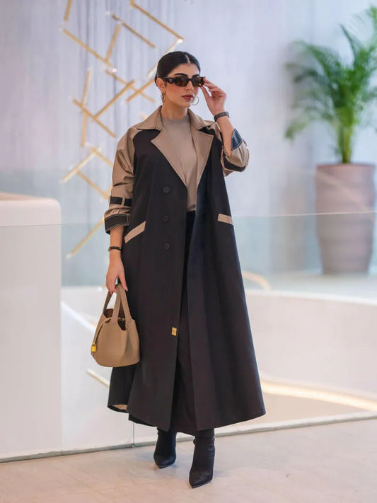 woman wearing a two-tone long structured blazer in black and olive-beige with sunglasses and a beige handbag