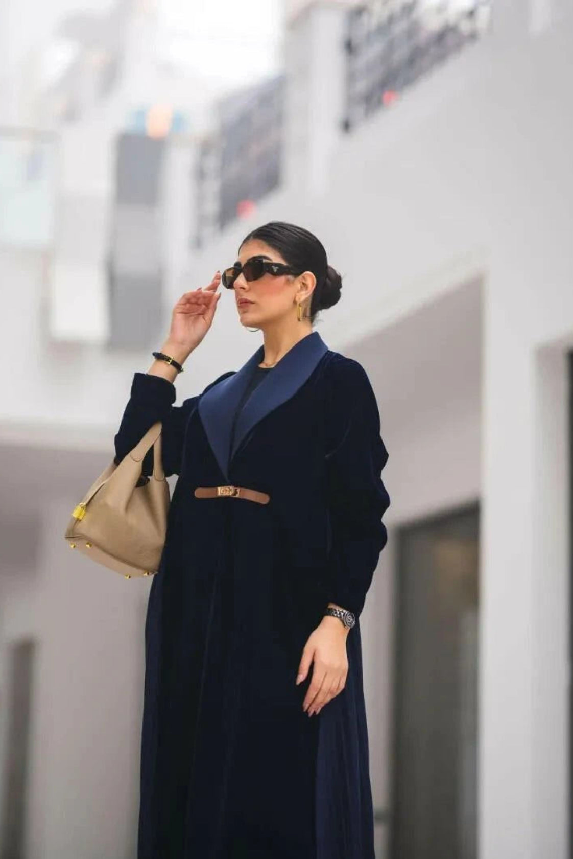 Woman wearing a navy blue velvet Midnira blazer-style abaya with pleats at the back and a structured lapel collar.