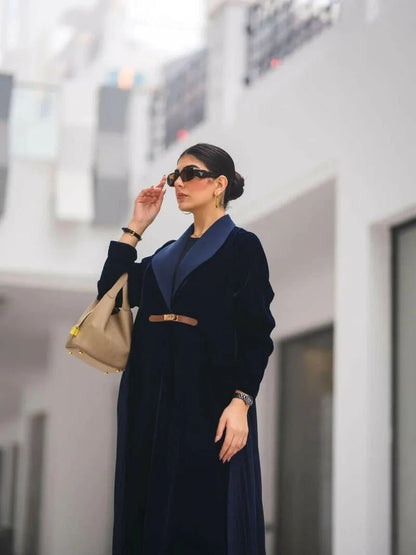 Woman wearing a navy blue velvet Midnira blazer-style abaya with pleats at the back and a structured lapel collar.