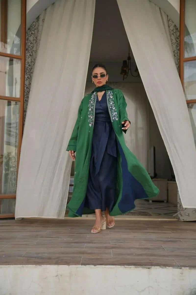 Evernavy green linen abaya with navy and silver embroidery on shoulders and cuffs, styled over navy innerwear.