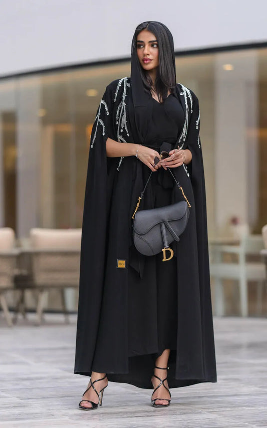 Elegant black cape abaya with silver cascading embroidery, flowing silhouette, and open front design