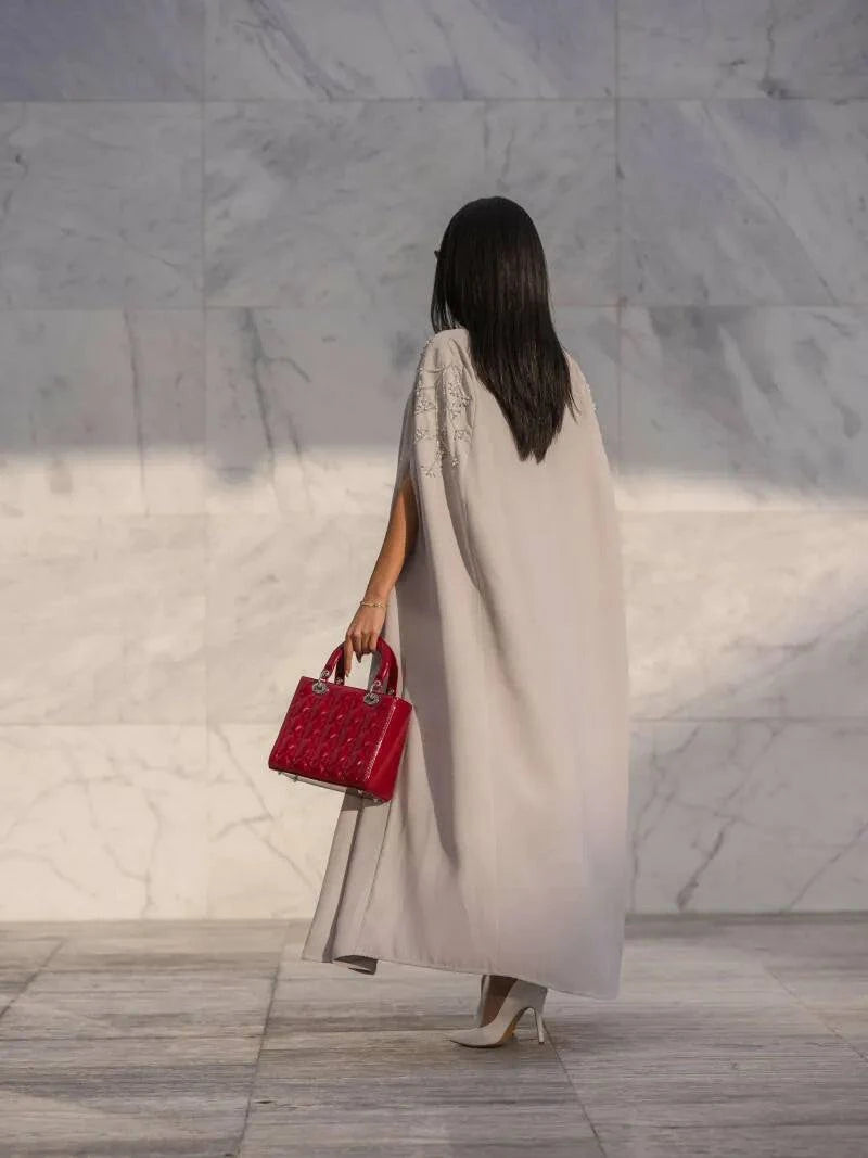 Light gray cape-style abaya with tonal embroidery, open front, and flowy crepe fabric for elegant layering.