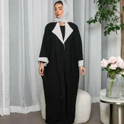 Woman wearing a freesize blazer abaya in black and grey crepe fabric with a relaxed fit and modern style