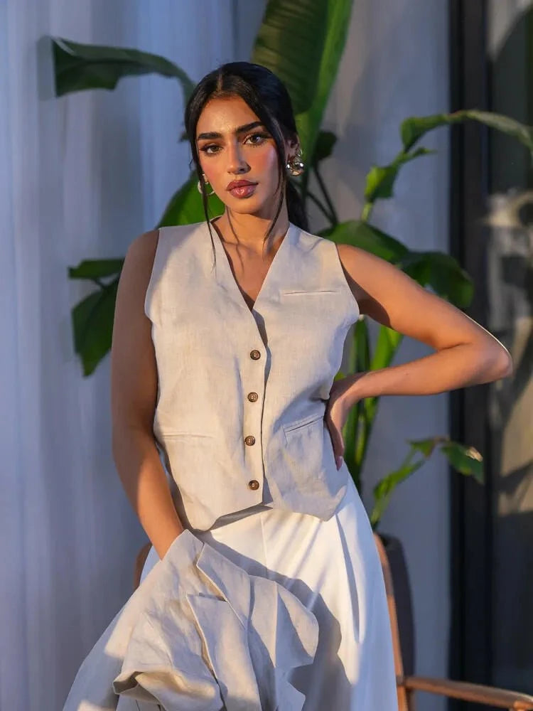 woman wearing tailored beige linen vest with four front buttons and subtle false pockets
