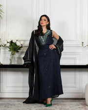 Navy blue linen three-piece set with sleeveless embroidered top, high-waisted skirt, and matching outer layer with green and silver threadwork called Midnight Vine