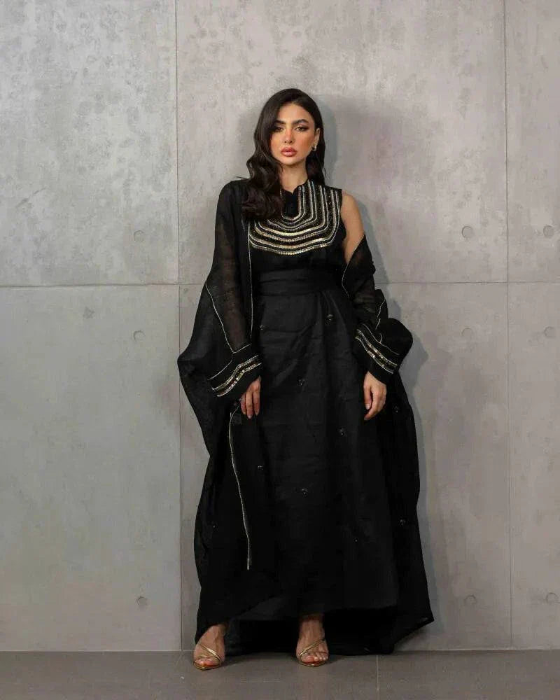 Elegant three-piece black linen set with sleeveless embroidered top, flowy skirt, and matching shawl.