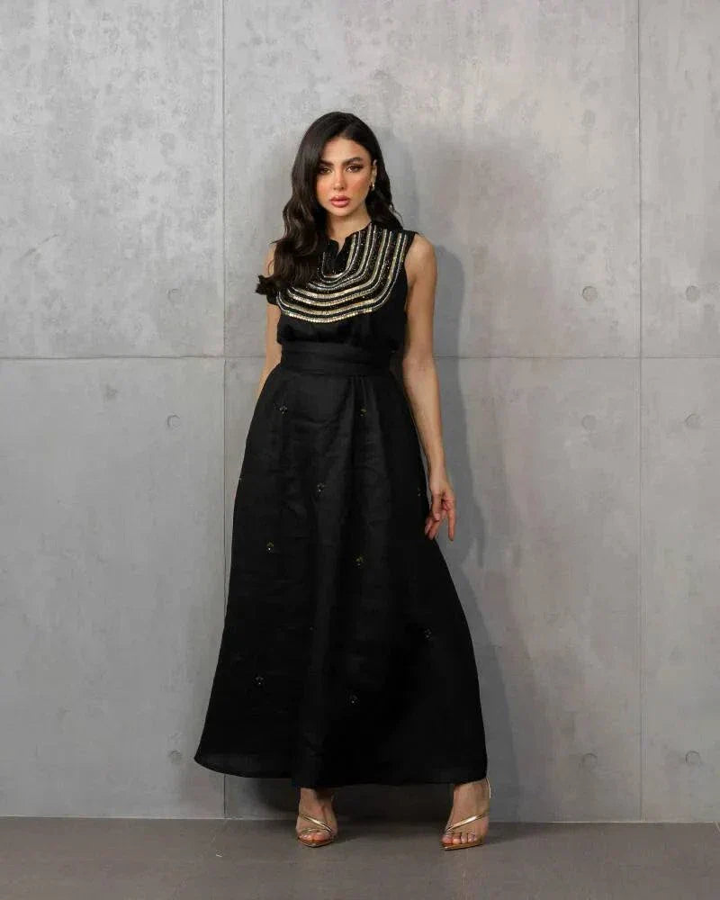 Elegant three-piece black linen set with sleeveless embroidered top, flowy skirt, and matching shawl.