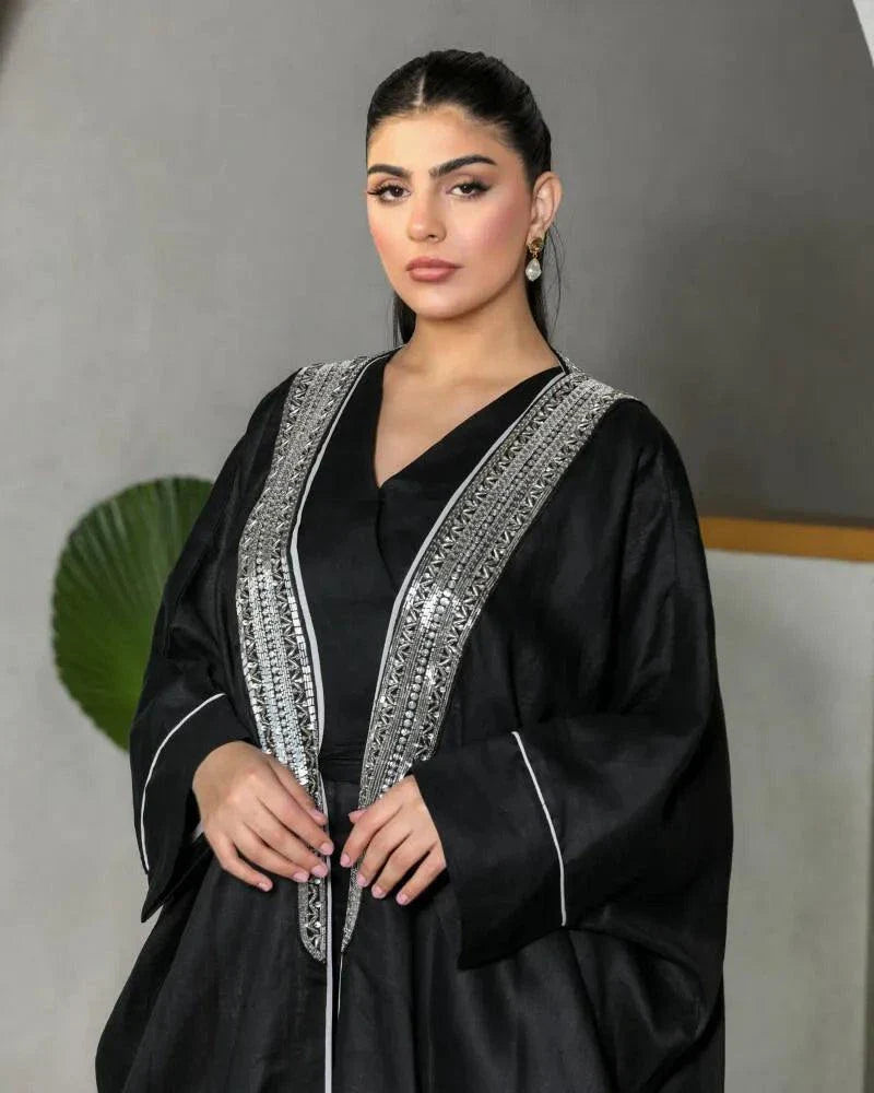 Luxurious black linen bisht with silver embellished neckline and subtle silver piping on sleeves, featuring a relaxed draped silhouette.
