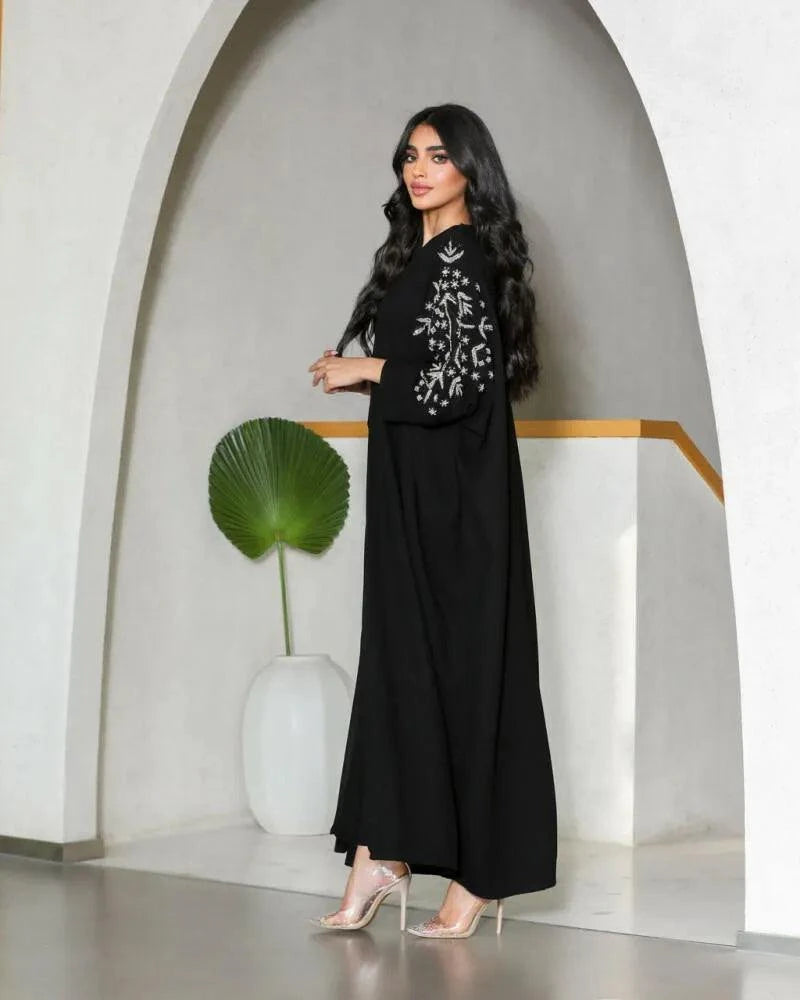 Black crepe abaya with silver nature-inspired embroidery on sleeves and relaxed V-neck design