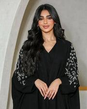 Black crepe abaya with silver nature-inspired embroidery on sleeves and V-neckline
