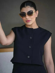 Woman wearing a sleek sleeveless black crepe vest with a round neckline and three front buttons, styled with sunglasses.