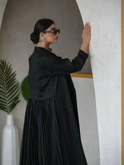 woman wearing elegant black linen abaya with structured collar and decorative buttons walking indoors