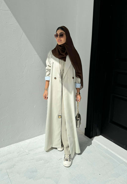 light beige linen blazer-style abaya with double-breasted front, structured shoulders, notched lapels, and contrast striped inner cuffs for sophisticated daily wear