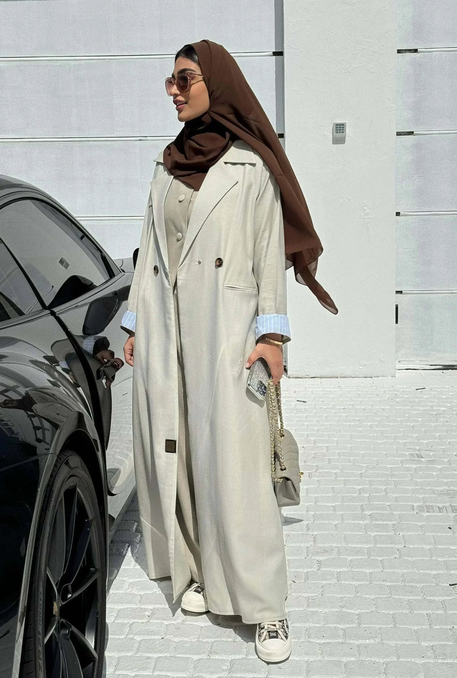 light beige linen blazer-style abaya with double-breasted front, structured shoulders, notched lapels, and contrast striped inner cuffs for sophisticated daily wear