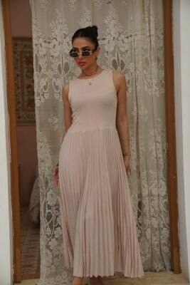 Sleeveless pleated beige dress with fitted top and flowing skirt perfect for elegant and comfortable wear