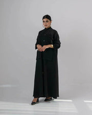 Woman wearing a sleek black crepe abaya with a Chinese collar and minimalist design.