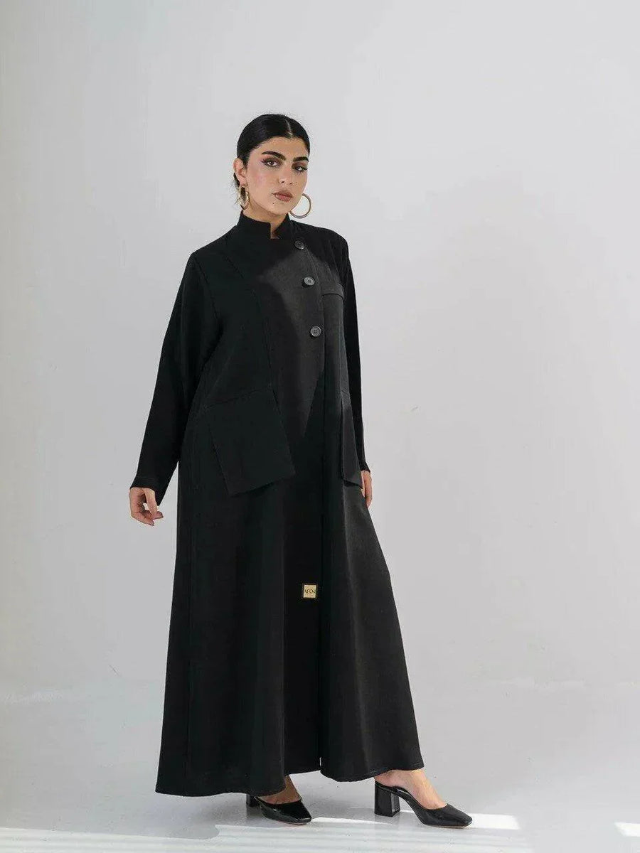 Woman wearing a sleek black crepe abaya with a Chinese collar and minimalist design.