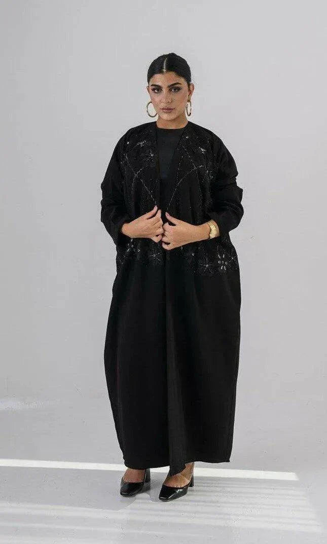 Elegant black abaya with intricate black-on-black embroidery and a soft open front design for modest, sophisticated wear