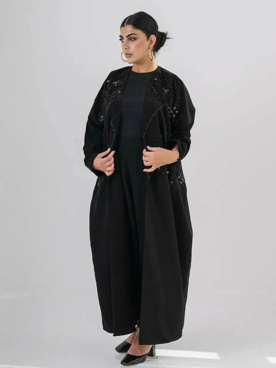 Elegant black abaya with intricate black-on-black embroidery and a soft open front design for modest, sophisticated wear