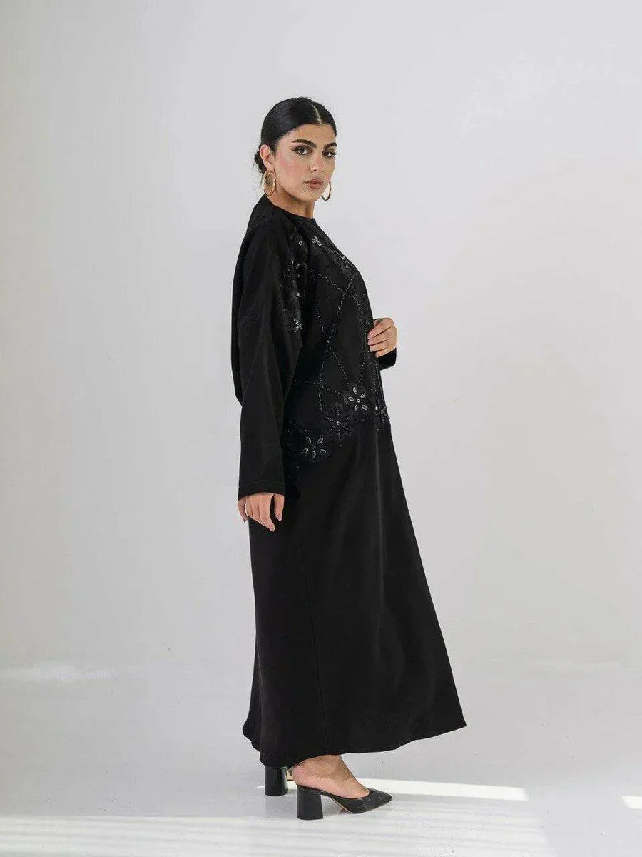 Elegant black abaya with intricate black-on-black embroidery and a soft open front design for modest, sophisticated wear