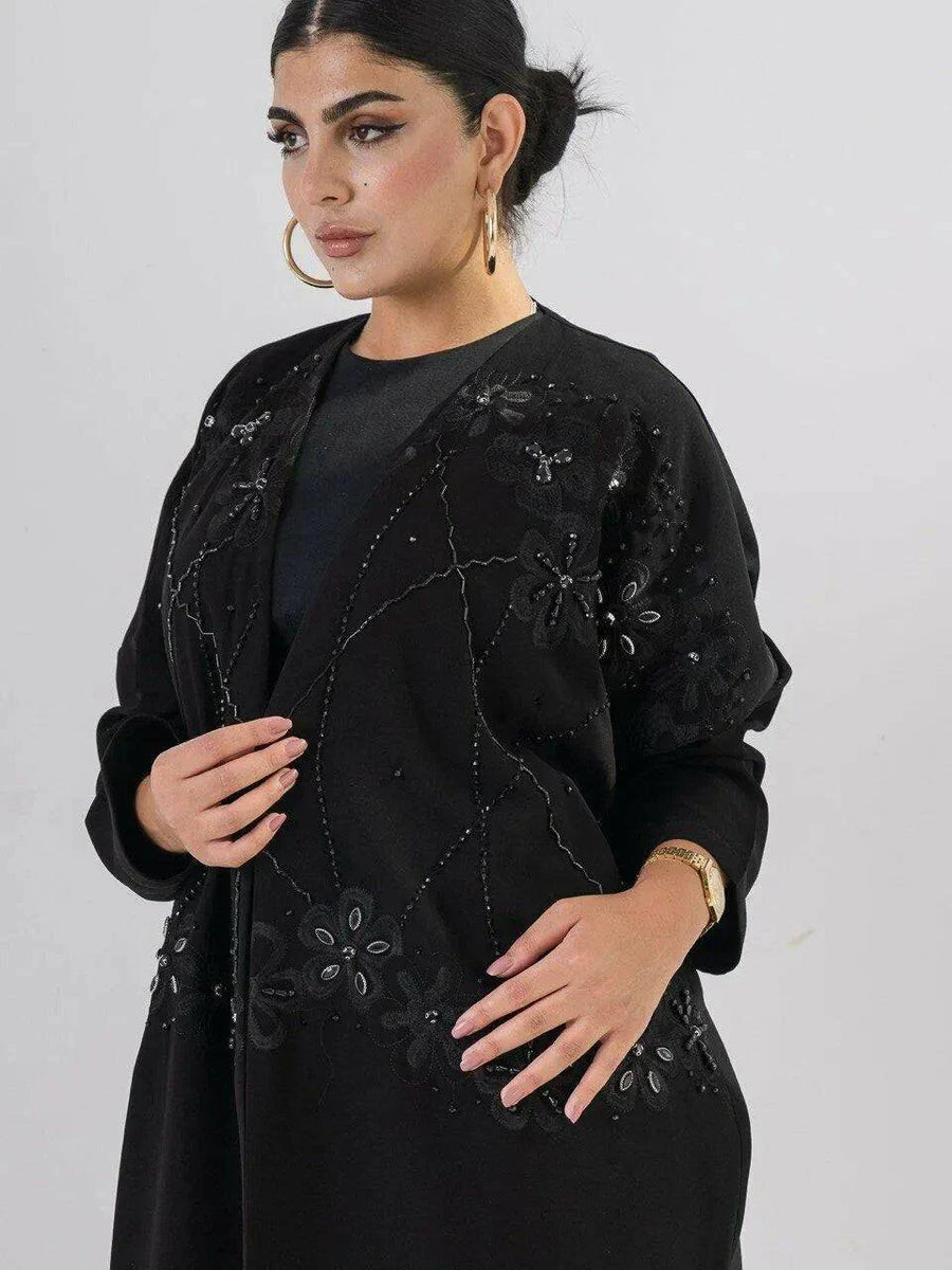 Elegant black abaya with intricate black-on-black embroidery and a soft open front design for modest, sophisticated wear