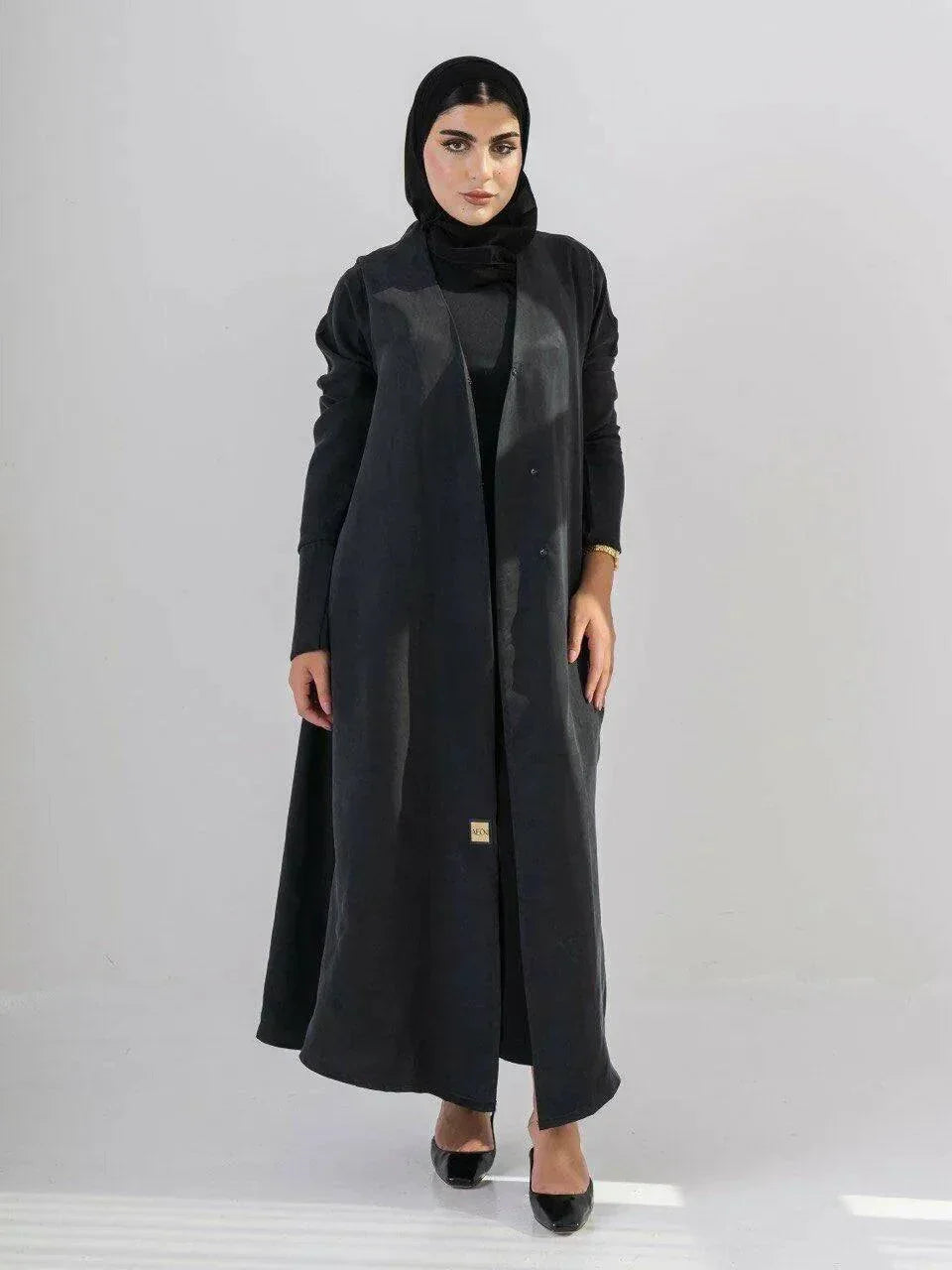 woman wearing luxurious black abaya made from soft cobra silk with elegant fluid drape and lightweight breathable fabric