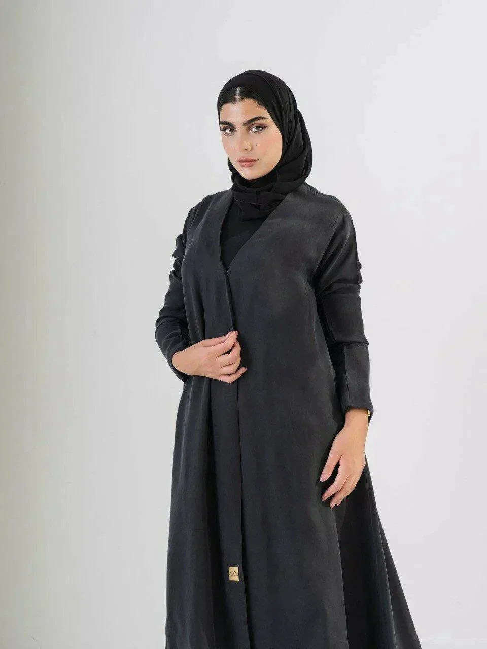 woman wearing luxurious black abaya made from soft cobra silk with elegant fluid drape and lightweight breathable fabric