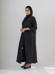 woman wearing luxurious black abaya made from soft cobra silk with elegant fluid drape and lightweight breathable fabric