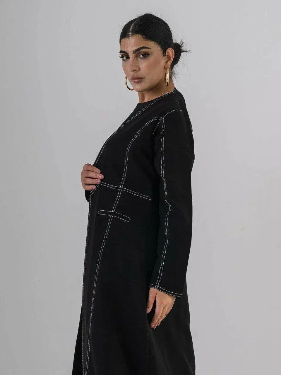 modern black crepe abaya with geometric contrast stitching and full-length silhouette