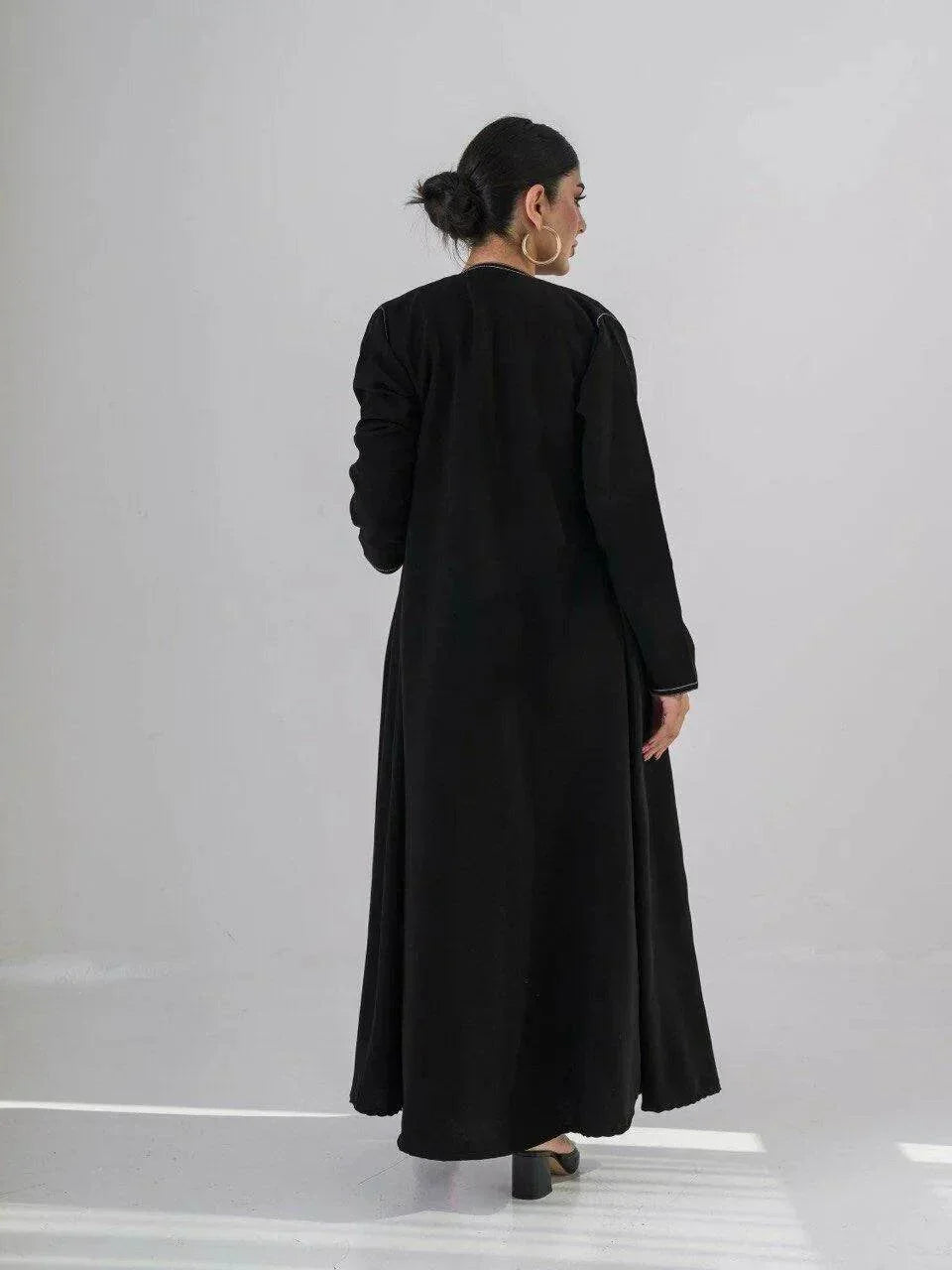 modern black crepe abaya with geometric contrast stitching and full-length silhouette