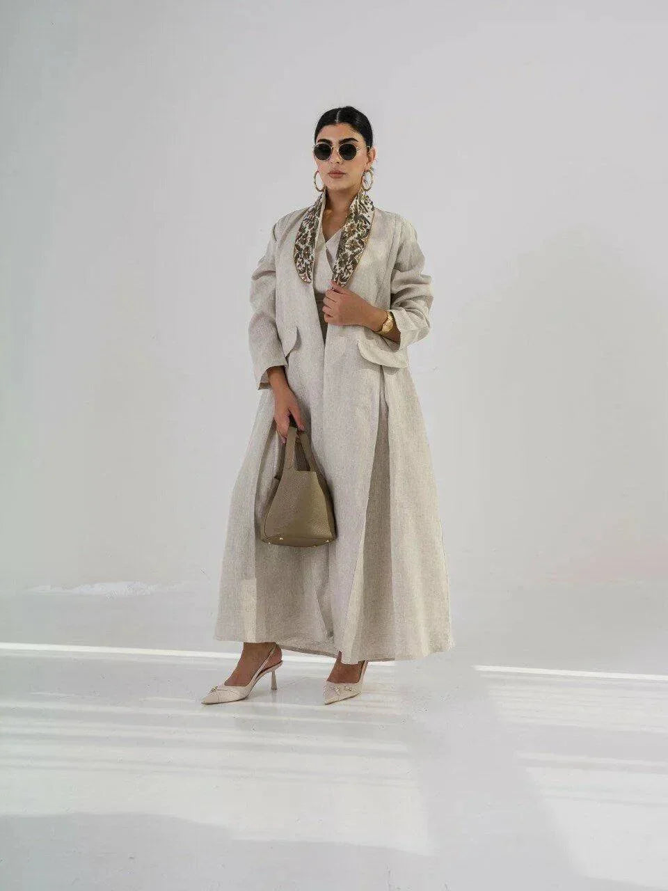 beige linen blazer-style abaya with floral embroidered collar and pleated pockets, styled for formal and everyday wear