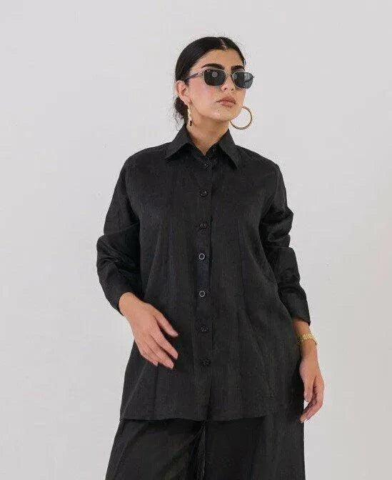 Woman wearing a breathable, relaxed-fit linen black blouse with buttons and long sleeves.
