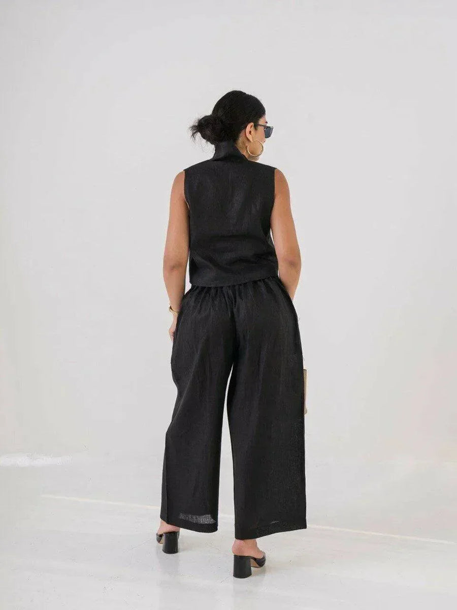 Woman wearing a short black linen vest with buttons, styled with sunglasses and gold accessories - Vest Black Linen