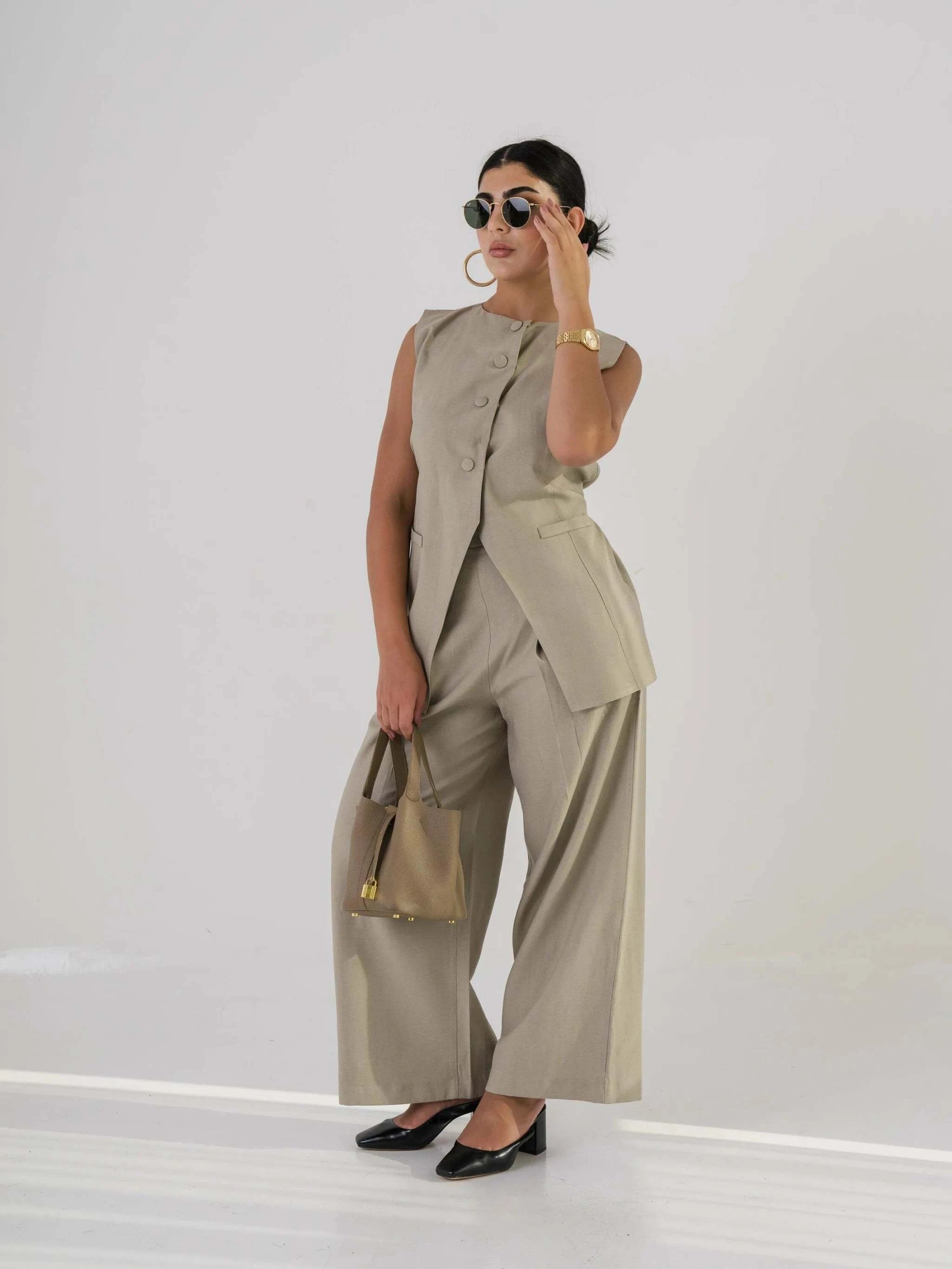 Beige Liberty linen vest styled with matching wide-leg pants and accessories for a chic modern look.