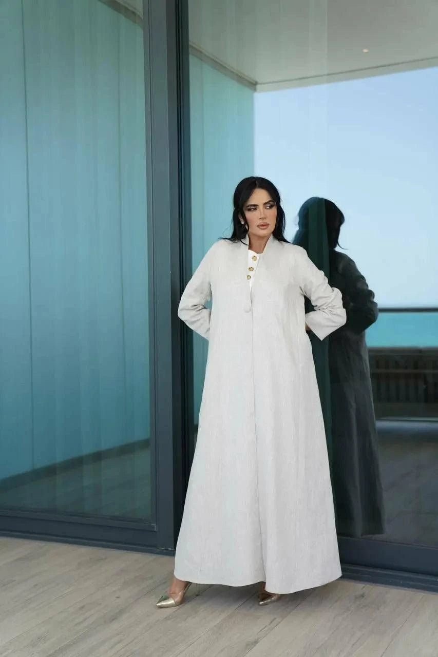 Minimal off-white linen Juna abaya with stand collar and statement buttons, perfect for warm weather and elegant casual looks