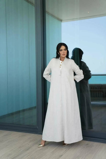 Minimal off-white linen Juna abaya with stand collar and statement buttons, perfect for warm weather and elegant casual looks